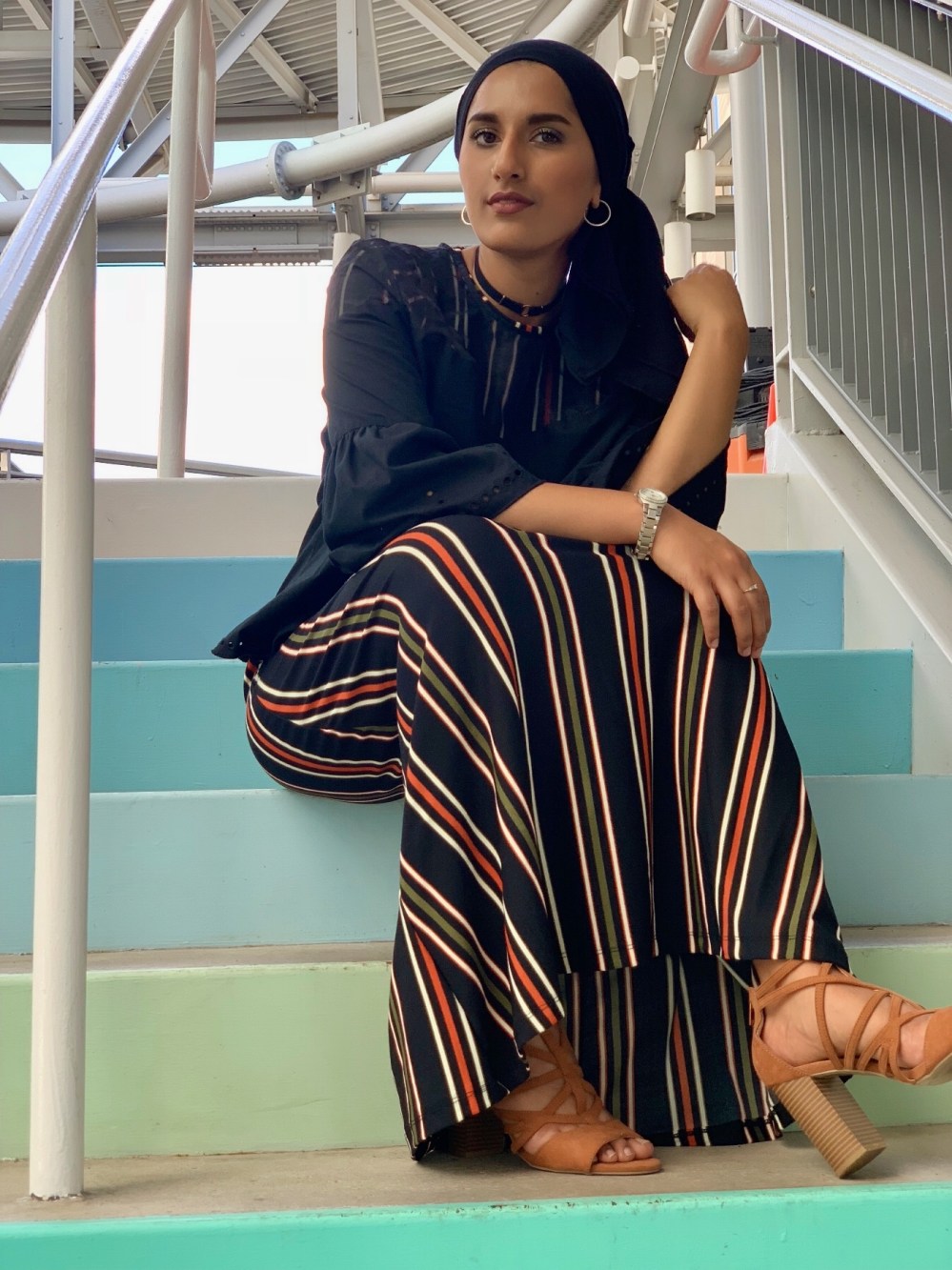 Rafa on stairs wearing dress, shirt and block heels